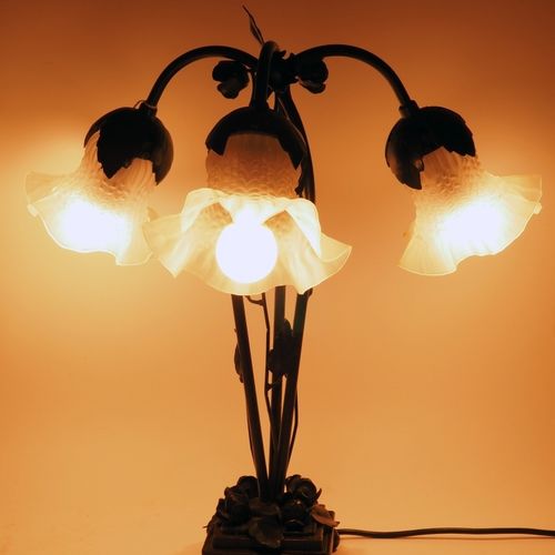 Three-armed table lamp, 20th century 三臂式台灯，20世纪

灯座由新艺术风格的黑色锻铁制成，有玫瑰和卷须的完整浮雕。在支架&hellip;