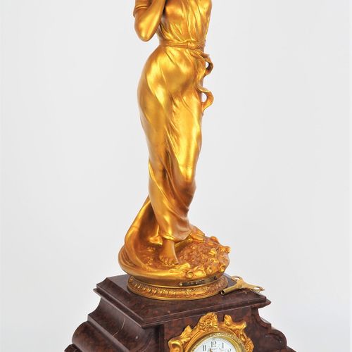 Large Art Nouveau figure clock 新艺术派大型人物钟

深红色大理石制成的表壳，有厚重的轮廓，在下边缘有四个带花卉装饰的弧形脚。在中&hellip;