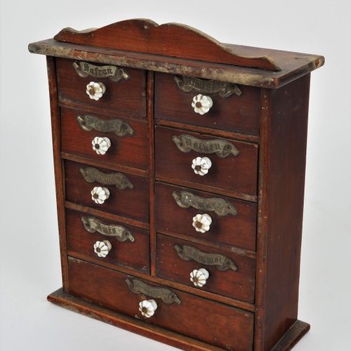 Spice cabinet around 1900 1900年左右的调料柜

由木材制成，可能是樱桃木，染成红色。长方形，有9个抽屉，都有瓷质的把手和内容的标签&hellip;
