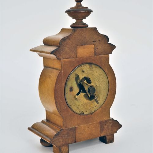 Small table clock around 1900 1900年左右的小台钟

樱桃木表壳，木质底部异形，有小脚。中央向外凸起，顶部有屋檐和转角。内置机芯&hellip;