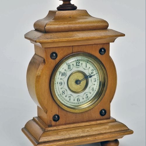 Small table clock around 1900 1900年左右的小台钟

樱桃木表壳，木质底部异形，有小脚。中央向外凸起，顶部有屋檐和转角。内置机芯&hellip;