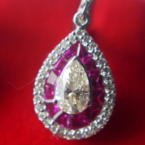 Null 一对18K白金、红宝石和钻石垂坠耳环

中央镶嵌一颗梨形钻石，周围是圆形明亮式切割钻石和口径切割红宝石，欧米茄扣。

(约梨形钻石1.20克拉，红宝石&hellip;