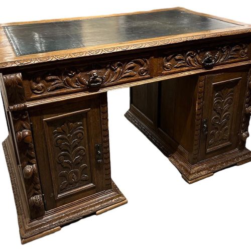 Null 一个19世纪的橡木雕花基座书桌

上面有两个抽屉和镶板门的工具皮顶，在一个基座上凸起。

(高75.5厘米 x 宽130厘米 x 长78.5厘米)