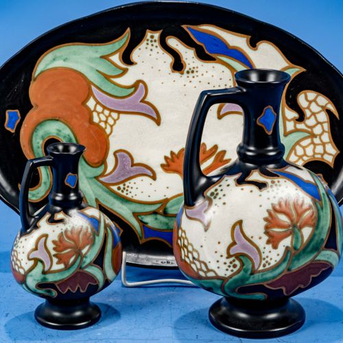 Null 
三件套 "GOUDA"，包括：椭圆形托盘（25,5 x 37,5厘米）和2个带手柄的水杯（高约23和16,5厘米），浅色的釉面，带有多色的略带抽象的&hellip;