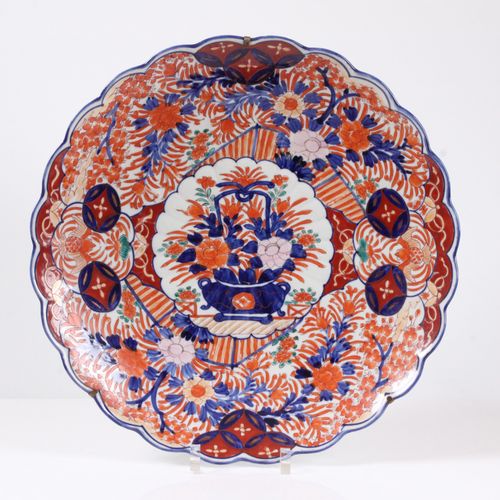 Null 大型伊万里盘。日本，19世纪。 瓷器，波浪形的边缘。镜子里有一束花，周围有铁红、蓝色和一点金色的花饰。直径46厘米。