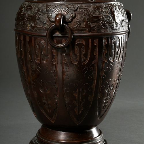 Null 
古典风格的环形手柄的优雅的青铜花瓶，周围有浮雕的饕餮面具装饰，底座有寿字纹，中国清朝，有配套的青铜支架，高29.9/34.8厘米