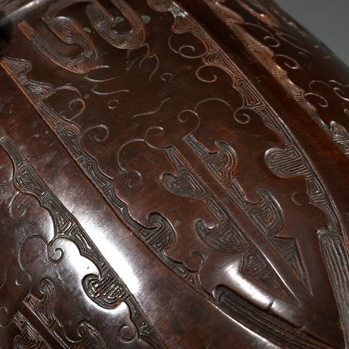 Null 
古典风格的环形手柄的优雅的青铜花瓶，周围有浮雕的饕餮面具装饰，底座有寿字纹，中国清朝，有配套的青铜支架，高29.9/34.8厘米