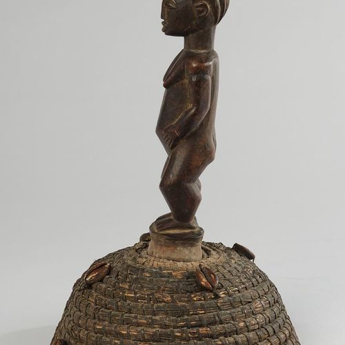Null 舞蹈附件，卢巴，刚果，非洲，木制的站立的女性形象，戴着植物纤维的帽子，上面有考利壳，高30厘米。
出处：科隆私人收藏