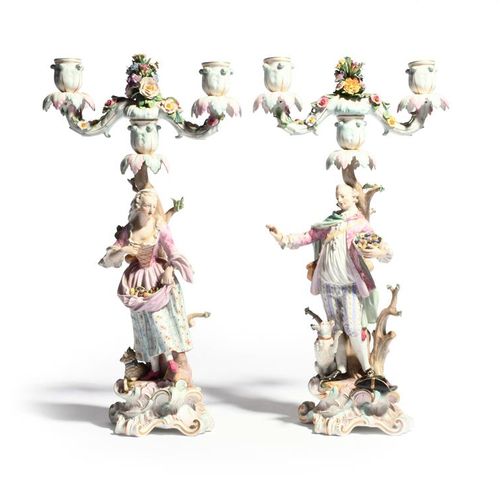 Null 一对迈森雕像烛台 19世纪，造型为英勇的牧羊人和他的同伴，带着水果篮，在高大的卷轴底座上，有一只狗和一只羊，在树桩前，支撑着两枝蜡烛的支架，两侧是花草&hellip;