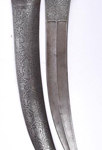 Null λ 一把巨大的波斯匕首（jambiya），弯曲的双刃水化钢刀，23英寸，刀尖膨胀，宽大的刀刃形成中间的脊，刀身凿有跪姿的人物和碗中的水果，并有银色的k&hellip;