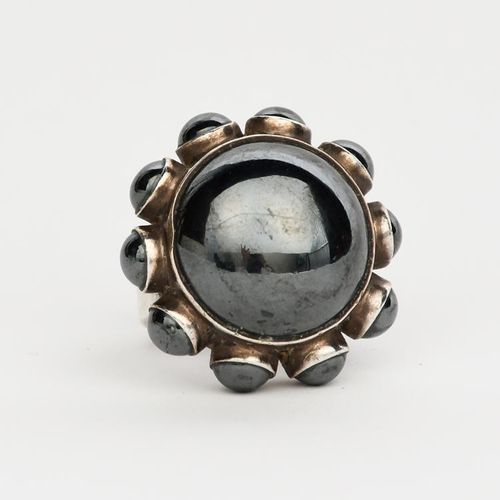 Null 由Astrid Fog设计的Georg Jensen银质赤铁矿戒指，型号为166，中央赤铁矿圆顶，领口有较小的圆顶边框，印有标记，宽3厘米。 出处：J&hellip;