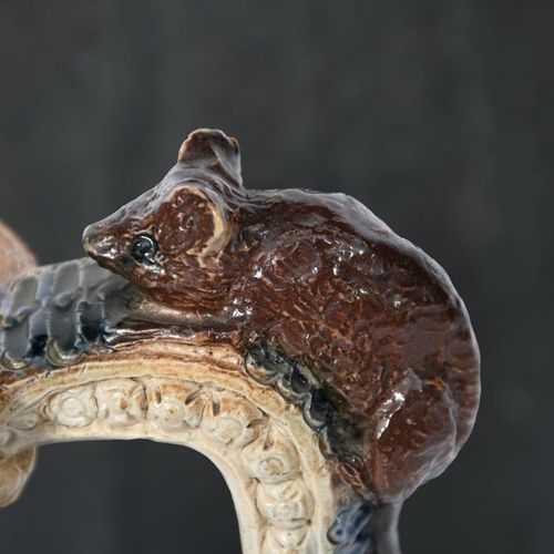 Null 罗伯特-华莱士-马丁的一个早期的马丁兄弟炻器壶，日期为1874年，肩部的形式，扩颈和有棱角的手柄，手柄上有老鼠爬到顶部的造型，壶身在有纹理的地面上刻有&hellip;