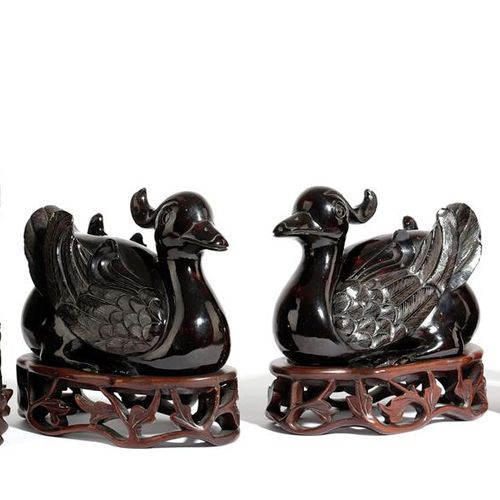 Null 一对20世纪中国琥珀风格的鸭子，蹲在地上，放在穿孔的硬木支架上，以及一对康熙风格的中国绿色硬石鹦鹉，站在雕刻的圆柱形基座和硬木支架上（4只），高26厘&hellip;