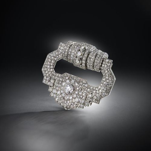 Null 卡地亚，一枚装饰艺术风格的钻石胸针，大约在1930年，设计成一个风格化的扣子，顶部形成一个阶梯状的半圆柱体，悬挂着一个宽大的如意图案，密镶圆形切割钻石&hellip;