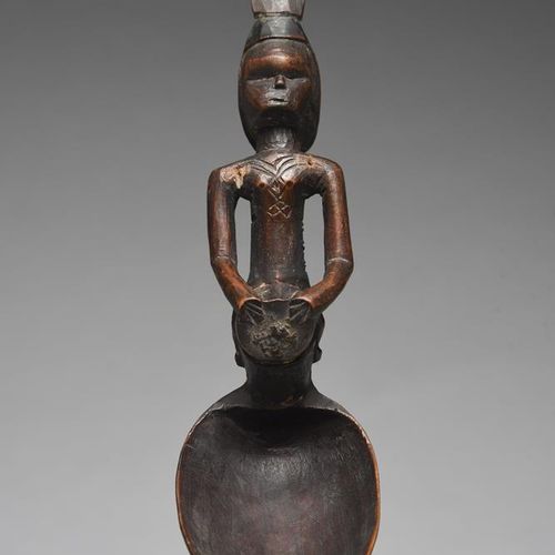 Null 刚果民主共和国的一个贝贝勺，柄部雕刻成一个骑在鼓上的人物，躯干上有疤痕和高大的头饰，长18厘米。