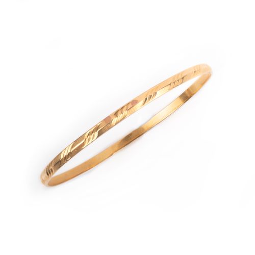 Null No reserve - a gold bangle, the solid band with engraved decoration, in hig&hellip;