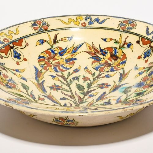 Null 一个库塔希亚伊兹尼克风格的盘子，18 世纪晚期/19 世纪，用蓝色、绿色、锰色、黄色和陶土红大胆地绘制了花和叶的正式排列、 
有些损坏和修复，26.8&hellip;