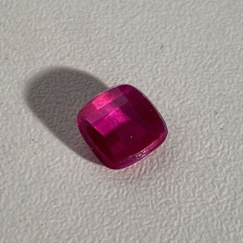 Un rubis synthétique taille coussin sur papier de couleur rouge rose PB : 3 cara&hellip;
