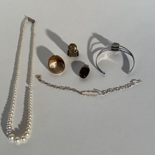 Un lot de bijoux fantaisie en l'état : un collier de perles et une chevalière en&hellip;