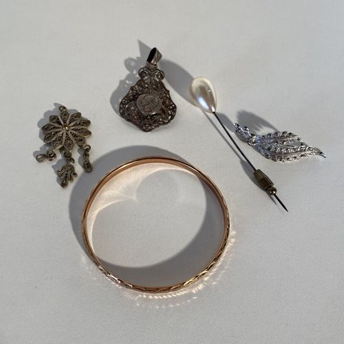 Un lot de métal comprenant : broche, bracelet rigide, 2 pendentifs et une épingl&hellip;