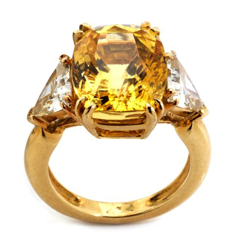 Gelber Saphir-Diamantring 环宽：53。
重量：约9.8克。
GG 750.

经典优雅的精美戒指，中央镶嵌着一颗混合枕形切割的浓黄色椭&hellip;