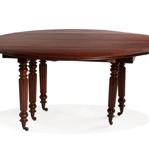 Null 圆形桃花心木和桃花心木饰面的餐桌，有两片叶子。它依靠六个锥形的腿，带有小圆点和环，用脚轮完成。
路易-菲利普时期。
直径：145厘米
(两条腿损坏)