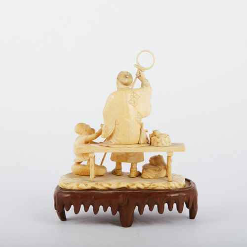 « Montreur de singe assis sur un banc ». 
Ivoire sculpté. 
Cachet rouge. 
JAPON,&hellip;