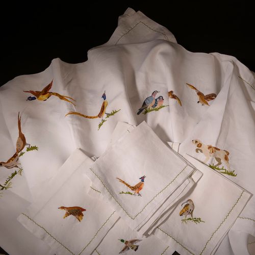 Nappe en coton blanc à décor brodé polychrome de volatiles et scènes de chasse e&hellip;