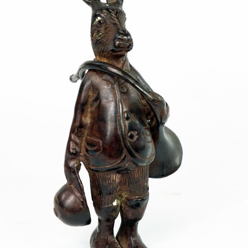 Null 带有棕色铜锈的青铜小雕像，表现了一只穿着猎人装束的兔子，带着狩猎的号角。

20世纪。

高度：20厘米