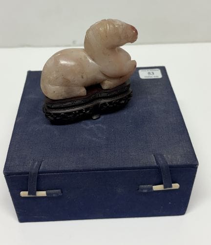 Liegendes Pferd aus weißem Jadeit mit rosa Adern. 