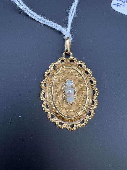Ein Anhänger aus Gelbgold mit kleinen weißen Perle