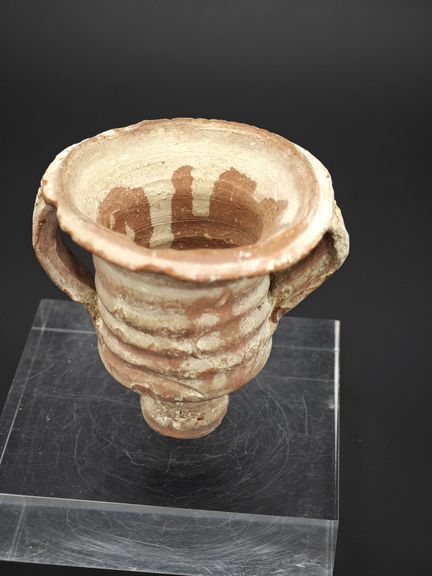 Poterie en terre cuite à deux anses .
Corps cylind
