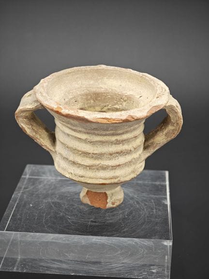Poterie en terre cuite à deux anses .
Corps cylind