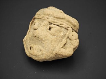 Petit masque stylisé archaïsant en terre cuite sab