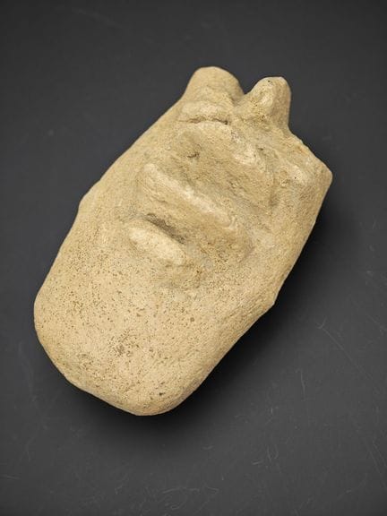 fragment de visage stylisé en terre cuite ancienne
