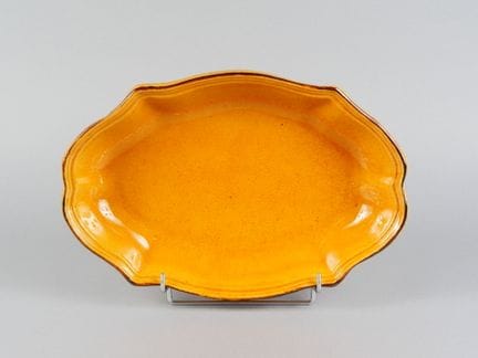 Oval, deep ceramic dish with a scalloped rim, glaz
