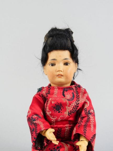Poupée asiatique. Tête en porcelaine, yeux marrons
