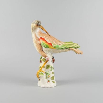 Oiseau en porcelaine polychrome sur un tronc d'arb