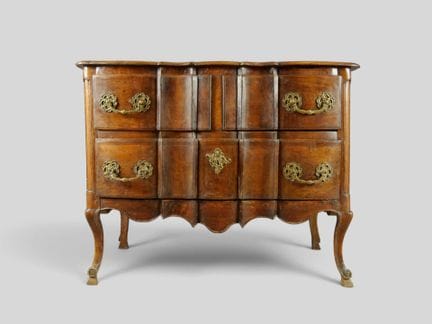 Commode à façade arbalète en noyer mouluré patiné.