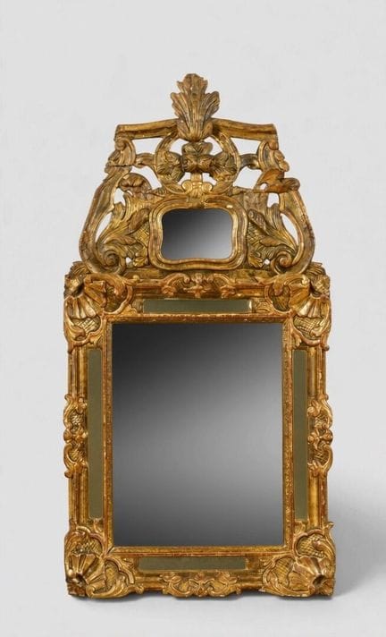 Miroir à fronton en bois sculpté doré, sommé de ri