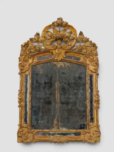 Miroir en chêne sculpté doré à fronton sommé d'un 