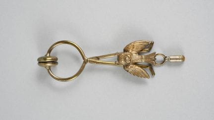 Rockklammer aus Metall mit Vogelverzierung.
(Abnut