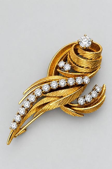 Un broche con forma de pluma de oro amarillo de 18