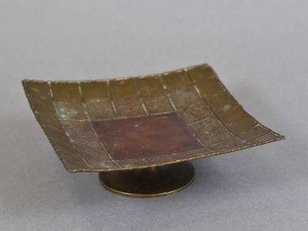 洛伊·迪南迪耶（约1930年活跃）
铜与黄铜制成的迪南风格小杯，配青铜杯座。附签名。
装饰艺术时期
