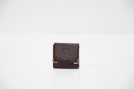 CARTIER
Porte-monnaie en cuir bordeaux, état d'usa