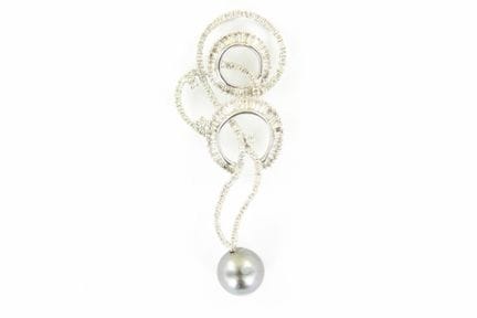 An 18K white gold pendant in a scroll design, set 