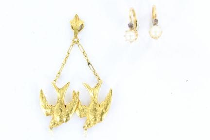 An 18K yellow gold pendant featuring two swallows 