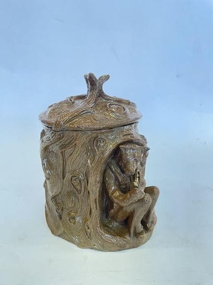 一只带盖的石质烟斗罐，饰有树桩和一只抽烟斗的熊（罐身有剥落，底座有撞痕），19世纪末时期