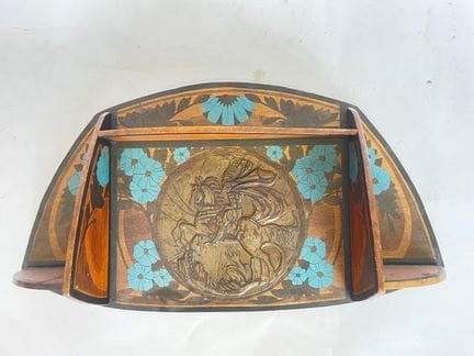 Ein Regal aus Holz mit Brandmalerei und blauem Blu