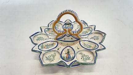 亨里奥特（HENRIOT），产自坎佩尔（QUIMPER）。一件彩釉陶制蛋盘，饰有布列塔尼人、貂皮纹和